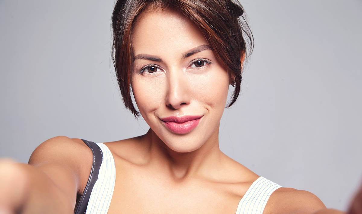 Young woman with beautiful skin and filler lips